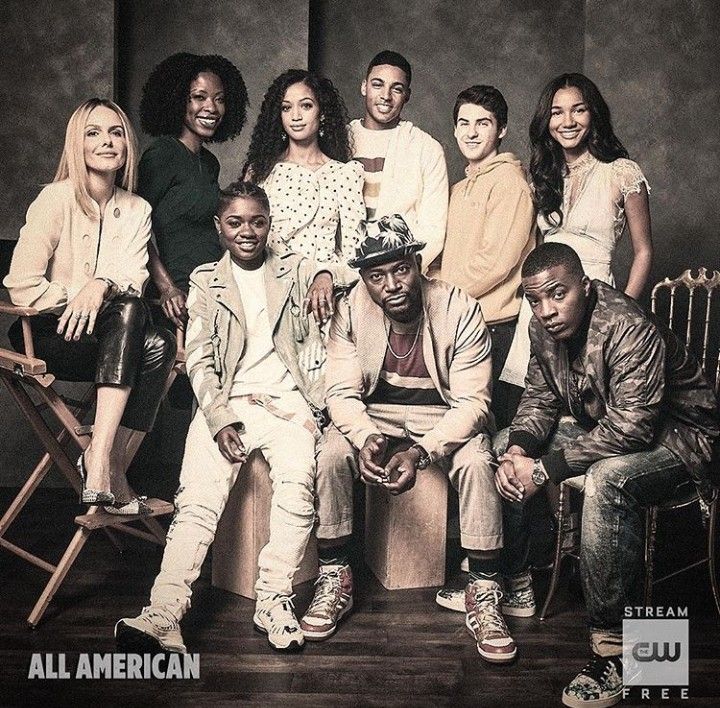 a group of people sitting next to each other in front of a black and white photo