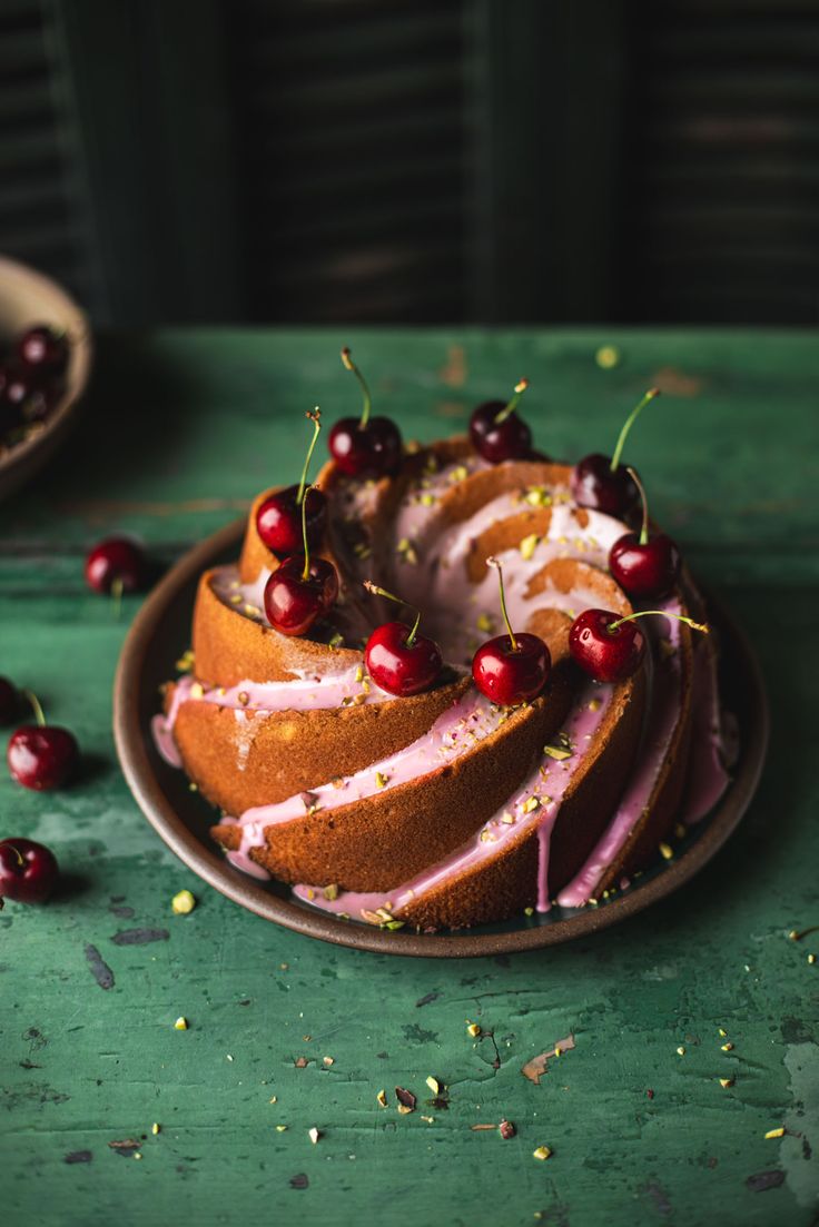 a bundt cake with icing and cherries on top