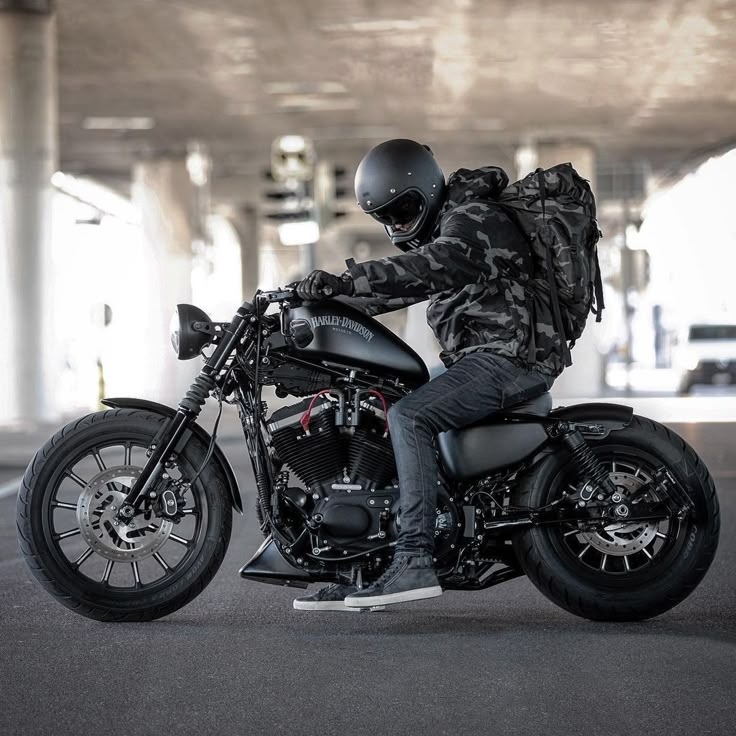 a man riding on the back of a motorcycle in a parking lot with no one around