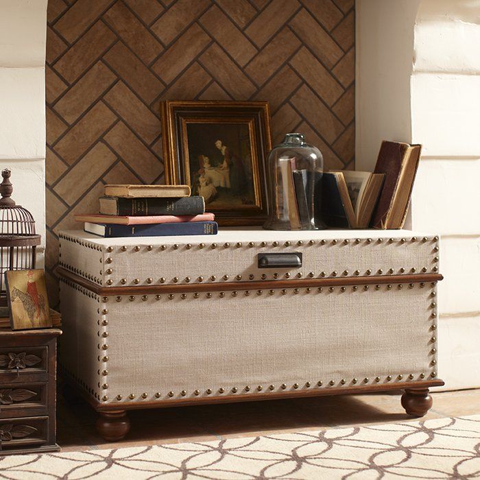 an old trunk sitting on top of a rug next to a birdcage and other items