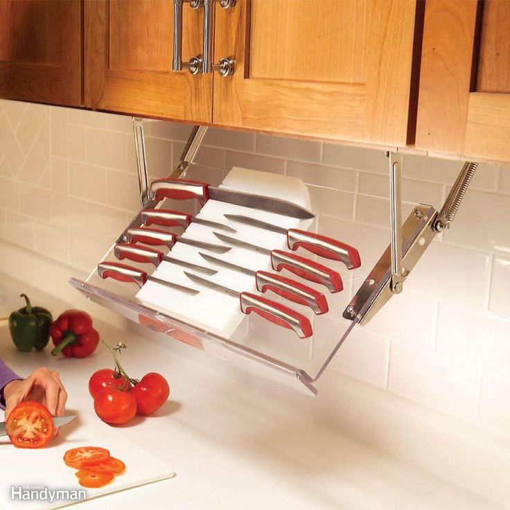 a woman cutting tomatoes on top of a counter next to a knife rack with knives