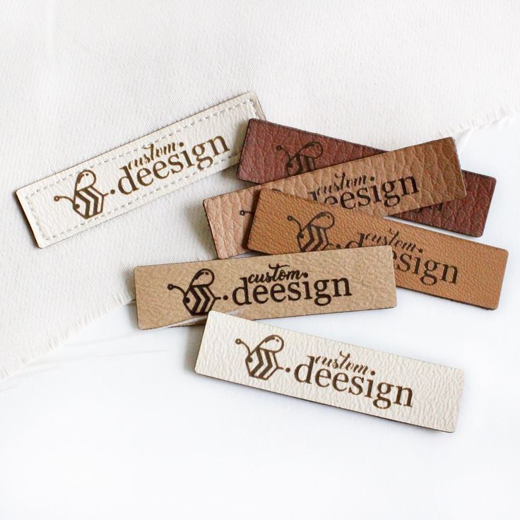 four leather name tags with the word design printed on them