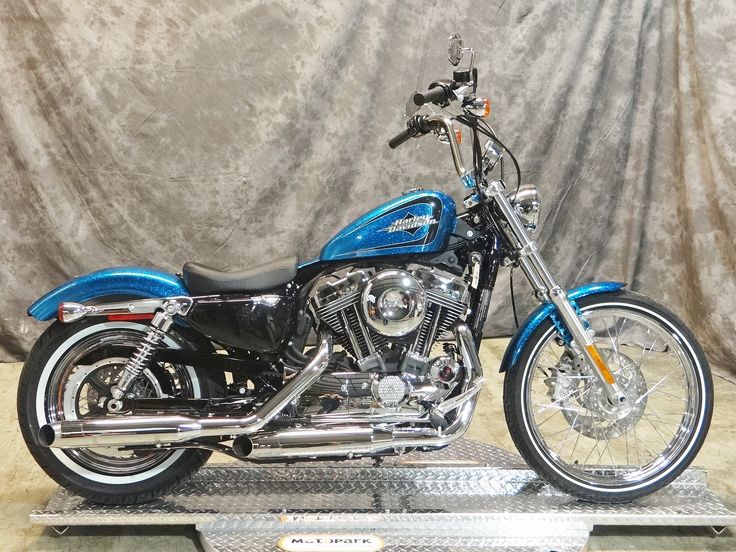 a blue motorcycle is sitting on a metal platform