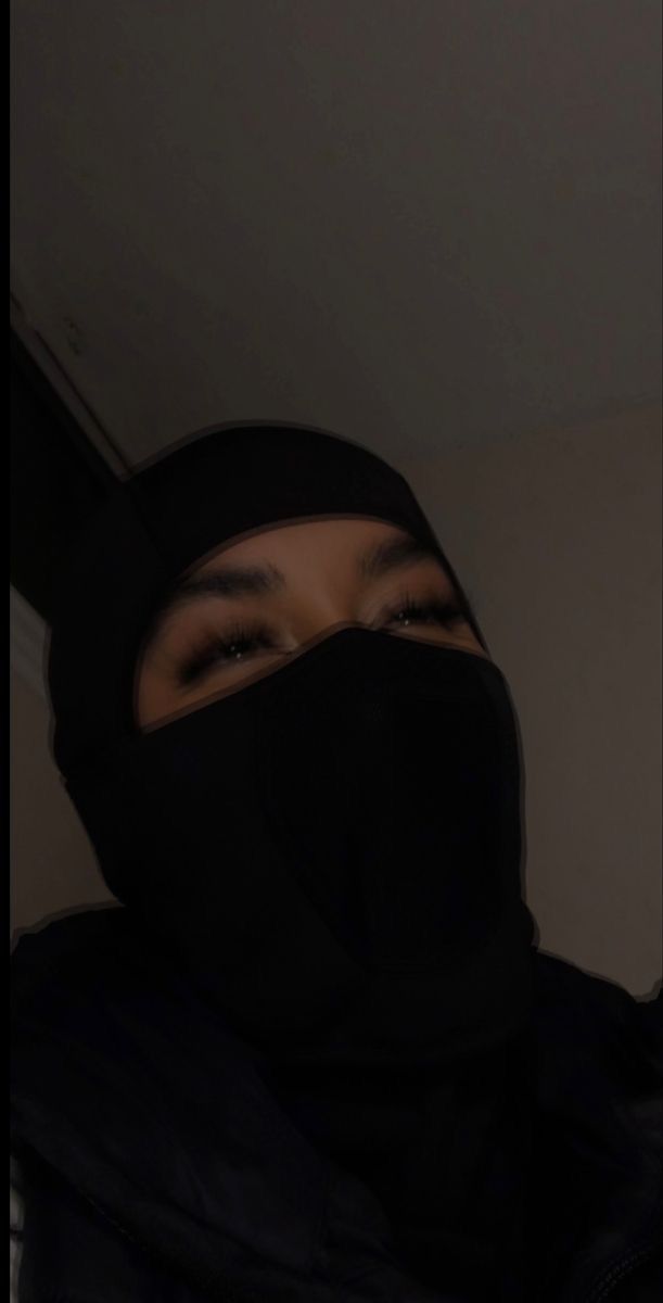 a person wearing a black mask and hood