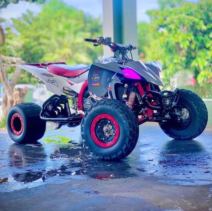 a pink and black four - wheeler is parked in the rain