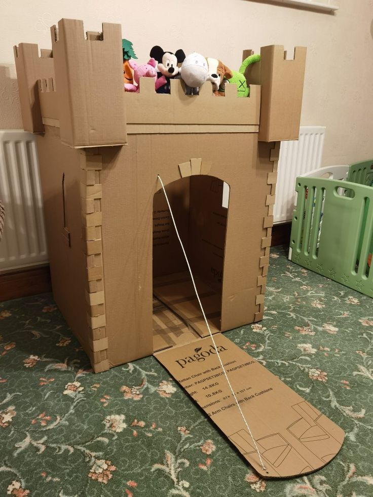 a cardboard castle made to look like it has stuffed animals on the top and bottom