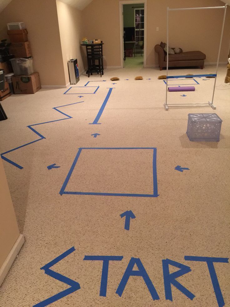 a room with blue tape on the floor that says start and arrows pointing in different directions