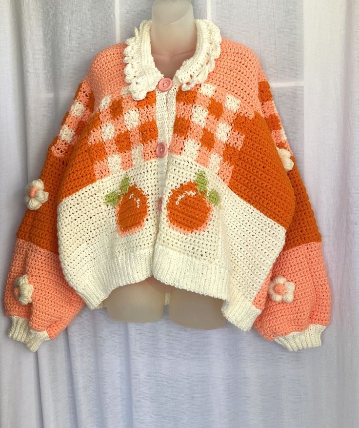 an orange and white knitted sweater with pumpkins on it