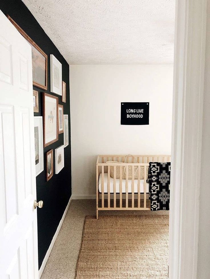 a baby's room with a crib and pictures on the wall above it