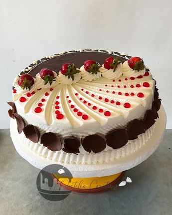 a white cake with chocolate and strawberries on top