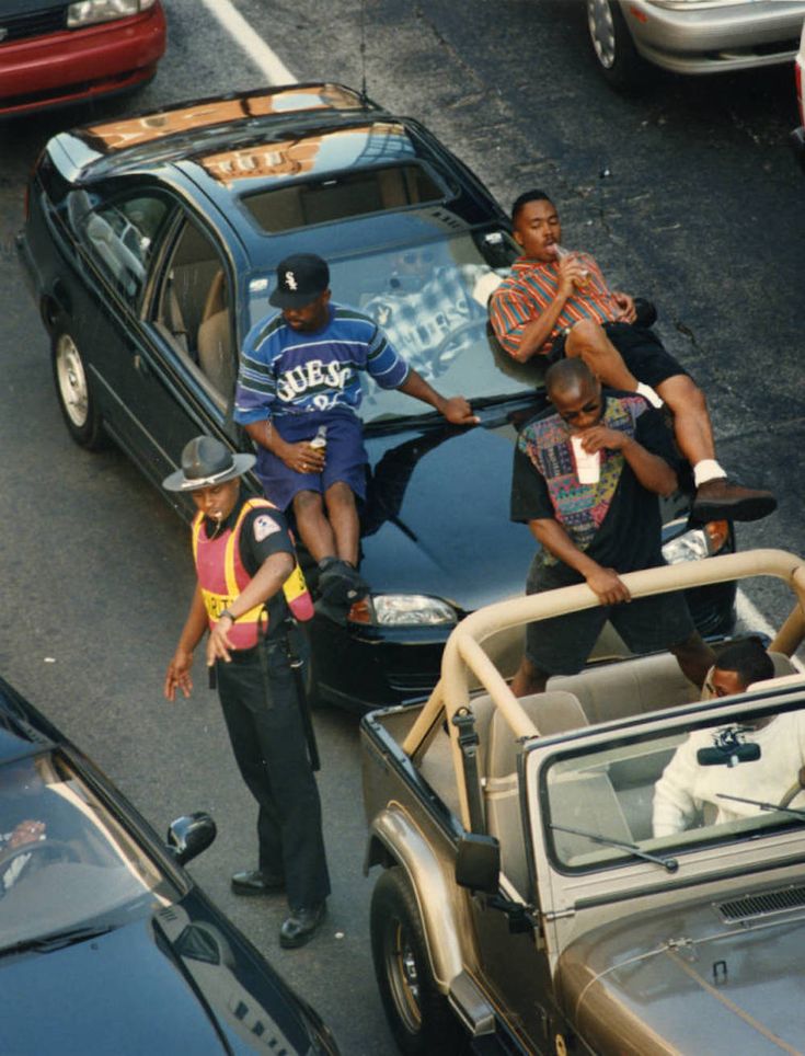 several people are sitting on the hood of a car