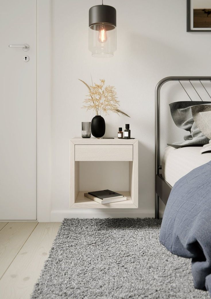 a bed room with a neatly made bed and a night stand on the side table