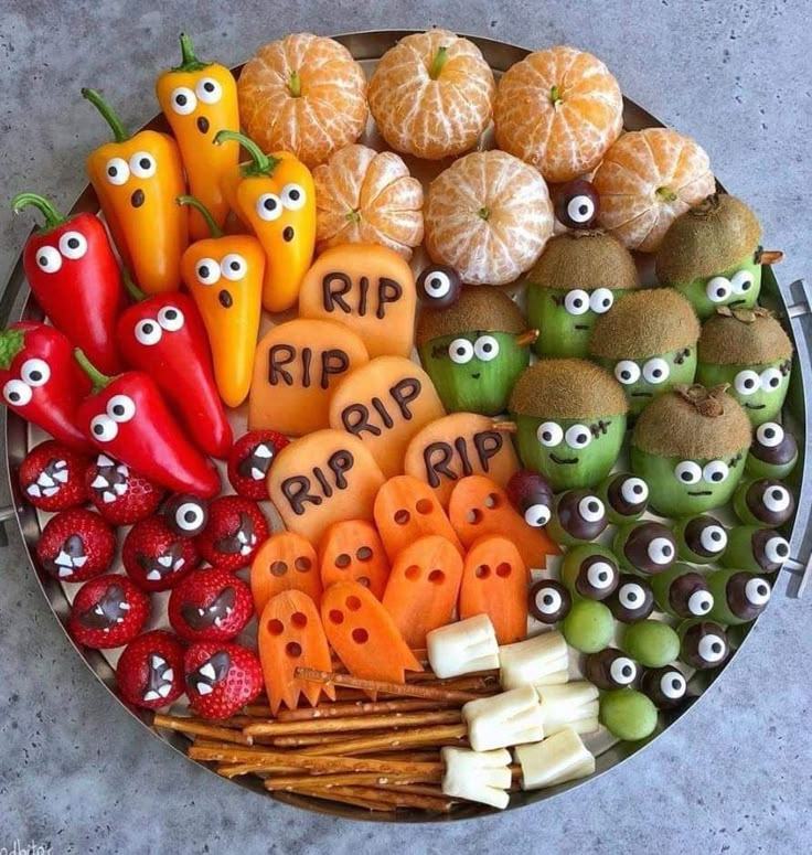 a platter filled with oranges, apples, and other fruits that have eyes on them