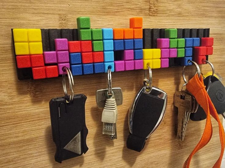 there are several key chains hanging on the pegs attached to the wall with magnets