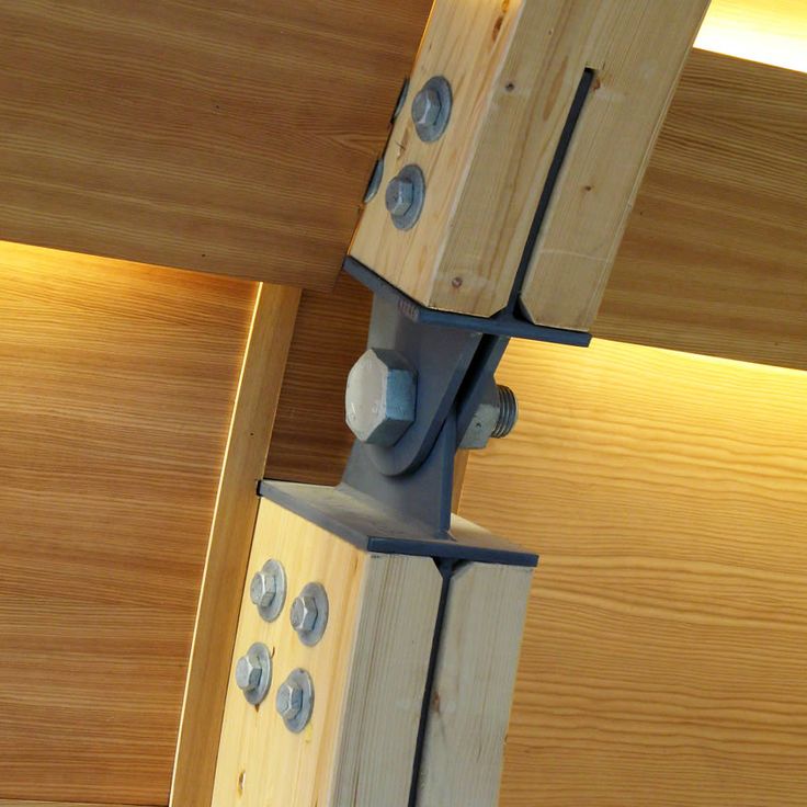 the underside of a wooden structure with screws attached to it and two lights on each side