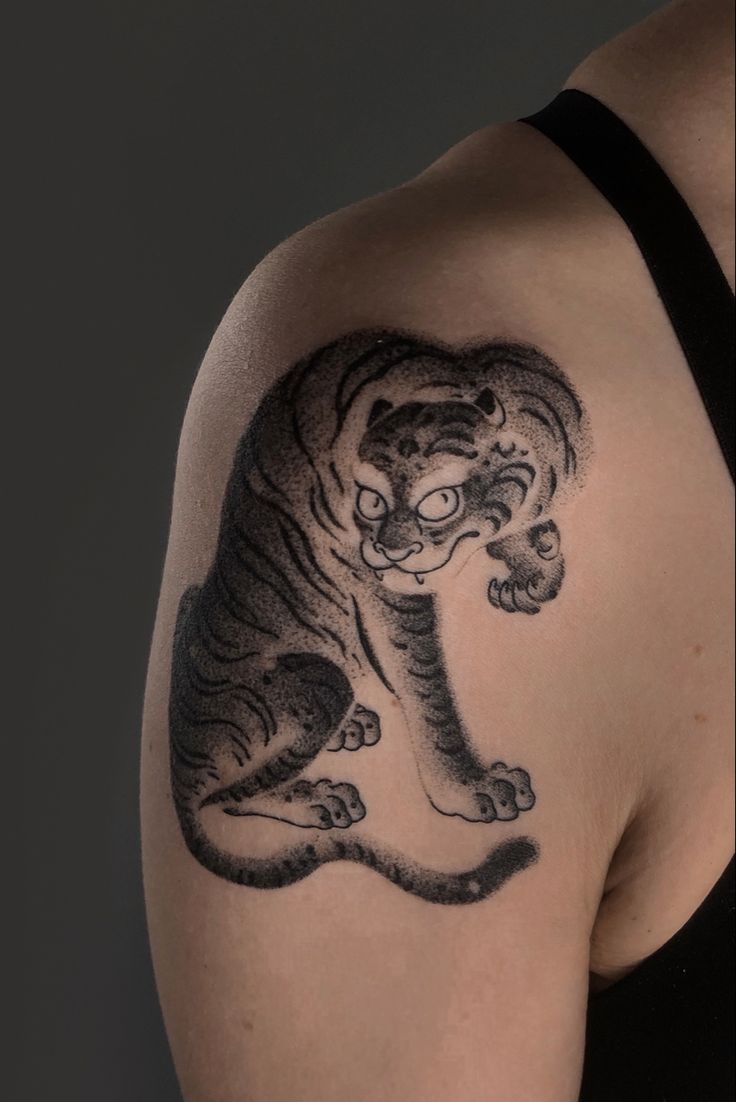 a woman with a tiger tattoo on her shoulder