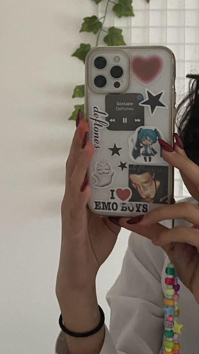 a woman holding up a cell phone case with stickers on the back and sides