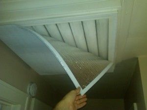 a person is holding up a piece of white paper in front of a ceiling fan