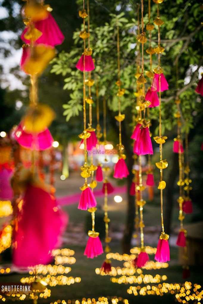 some pink and yellow decorations hanging from trees