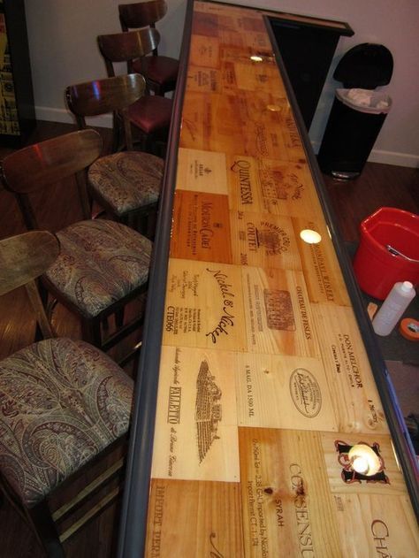 a long wooden table with many different types of wood on it and some chairs in the background