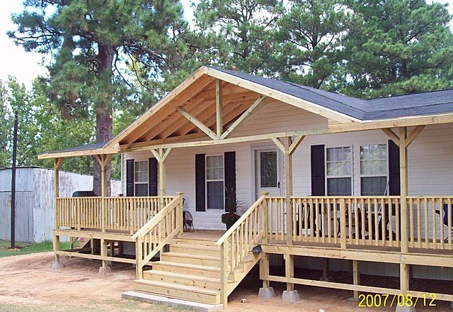 a mobile home with porches and steps leading to the front door is shown in this image