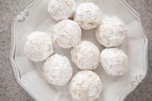 a white plate topped with snowball cookies