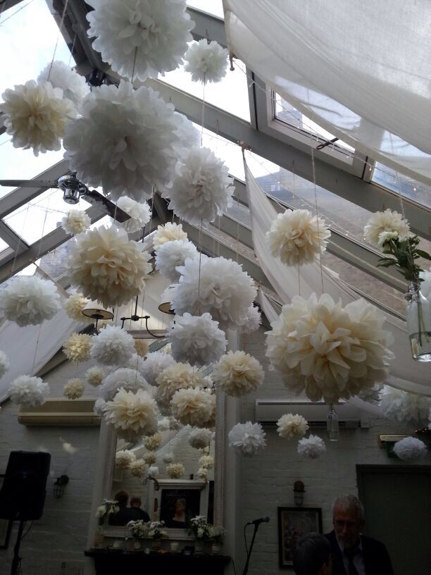 some white flowers hanging from the ceiling in a room