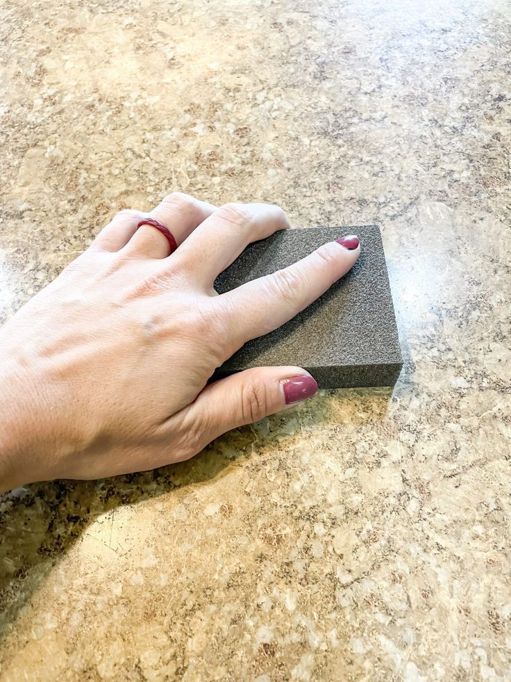 a woman's hand on top of a granite surface