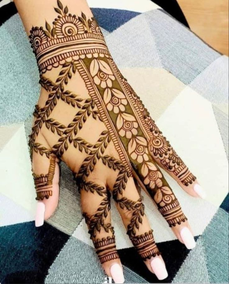 a woman's hand with henna tattoos on it