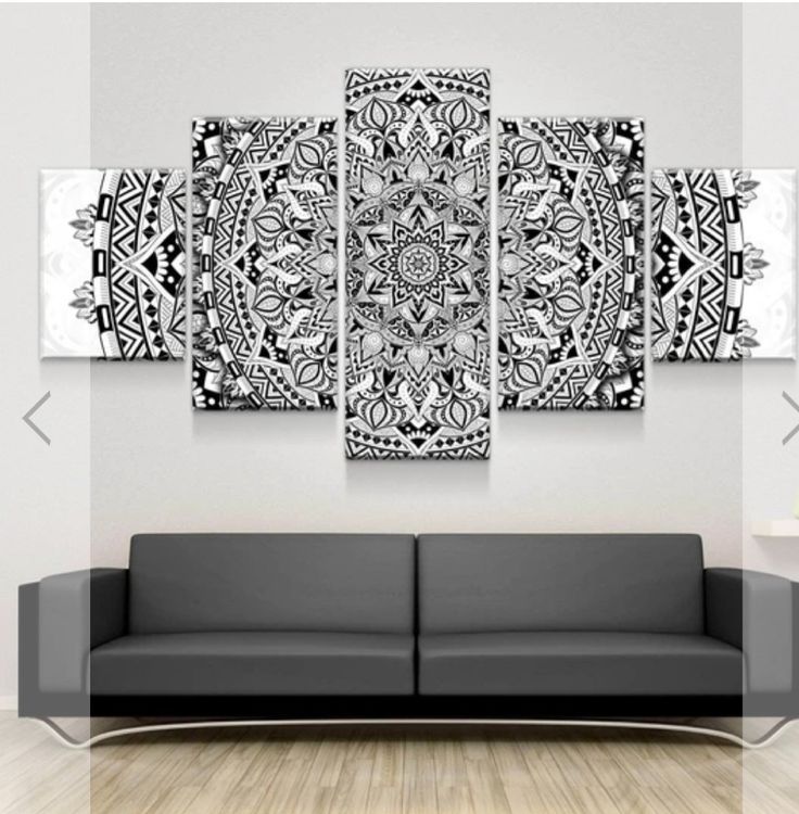 a black and white wall hanging in a living room with a couch next to it