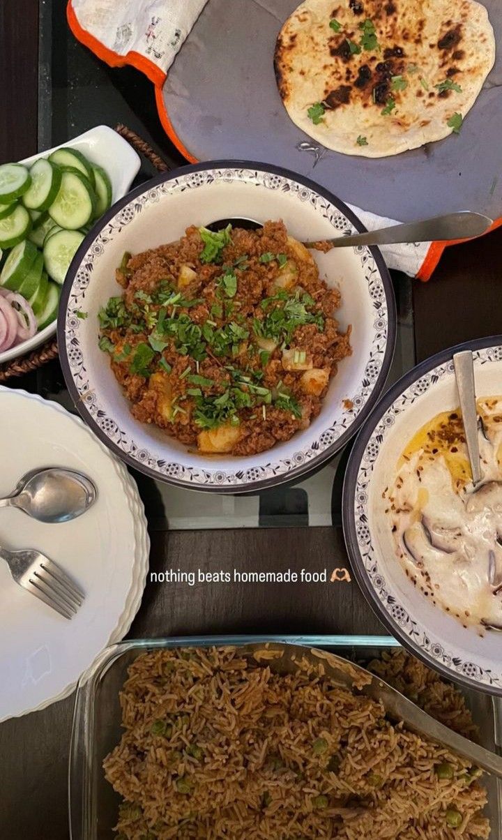 several plates of food are arranged on a table with utensils and spoons