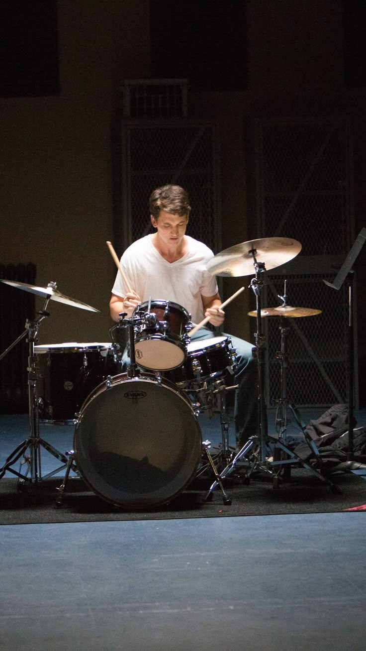 a man is playing drums on stage