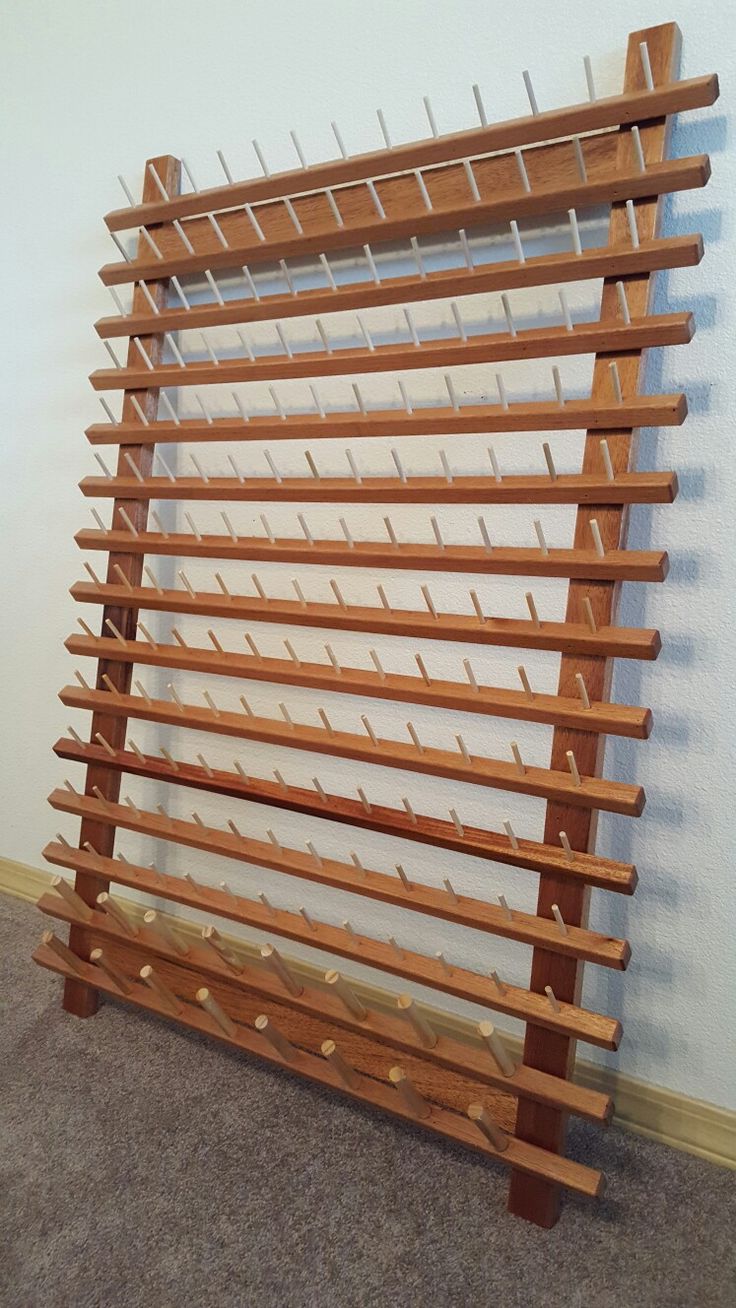 a wooden wine rack in the corner of a room with carpeted floor and walls