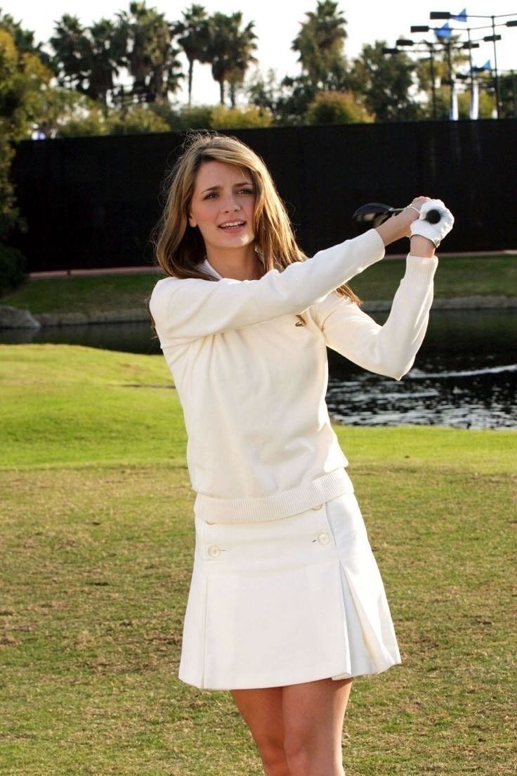 a woman in a white dress holding a baseball bat