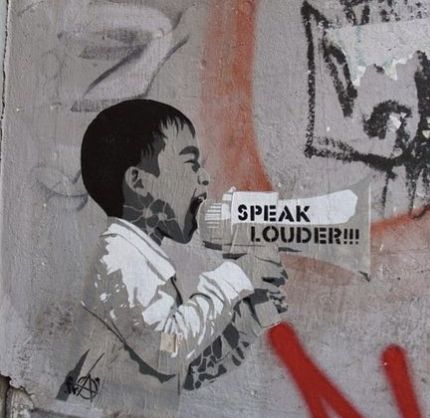 graffiti on the side of a building with a man shouting into a megaphone that reads speak louder