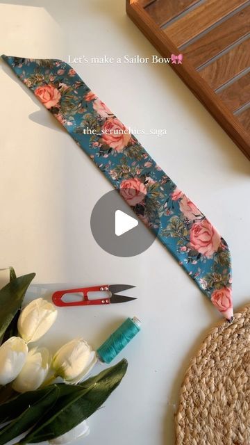 the scissors are next to some flowers and other crafting supplies on top of a table