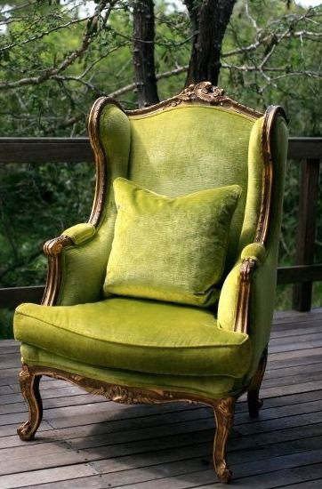 a green chair sitting on top of a wooden deck