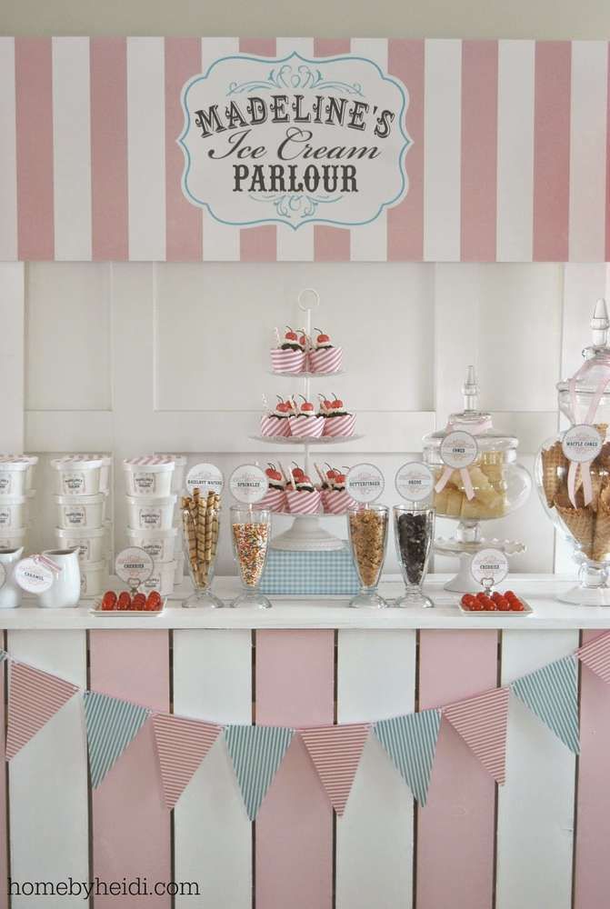 a dessert table with pink and white striped walls