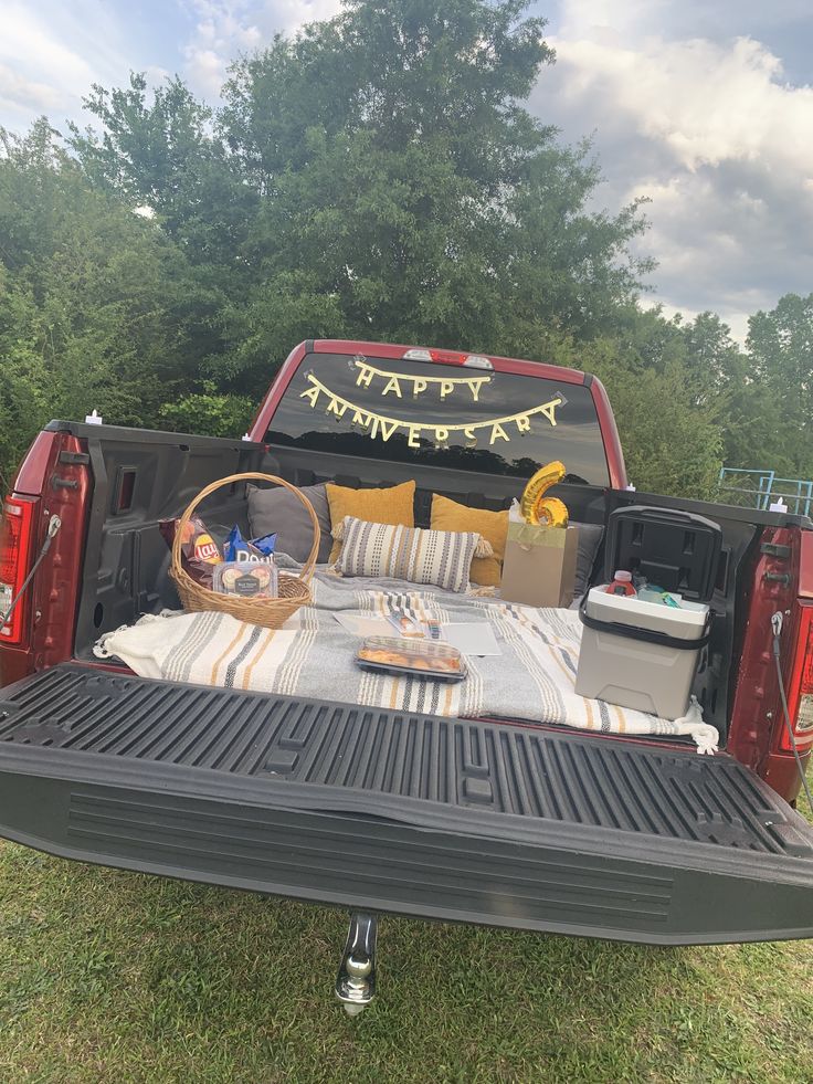 the back end of a pickup truck with an open bed and picnic items on it