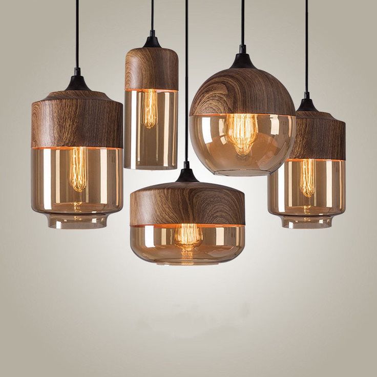 five light fixtures hanging from a ceiling with wood and glass in different shapes, sizes and colors