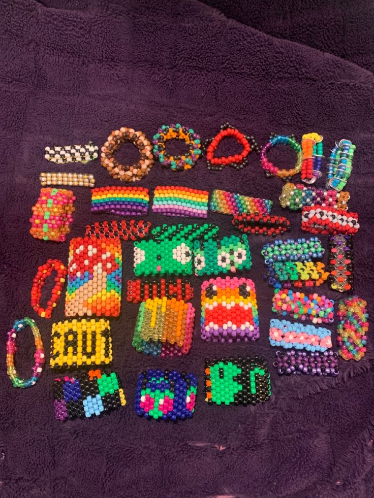 a bunch of beads and bracelets laid out on a purple blanket