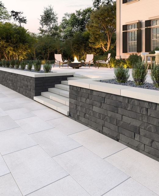 an outdoor patio with stone steps and planters