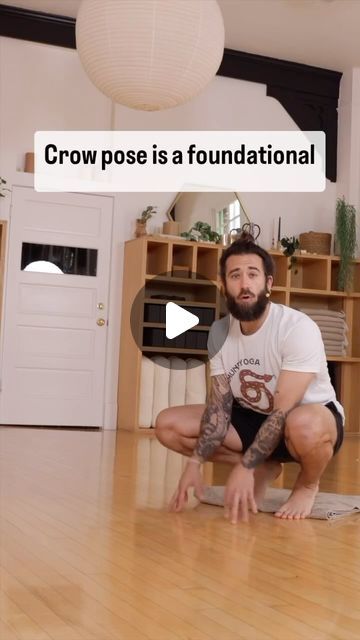 a man squatting on the floor in front of a tv screen with text reading, crow pose is a foundational