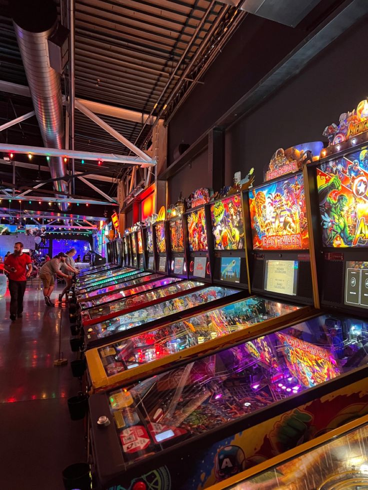 several pinball machines lined up in a room