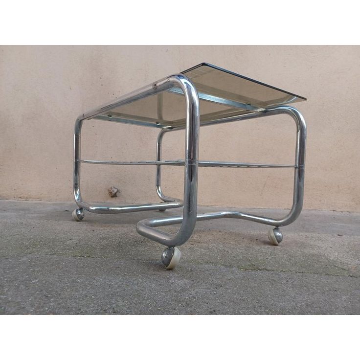 a small metal table sitting on top of a cement floor