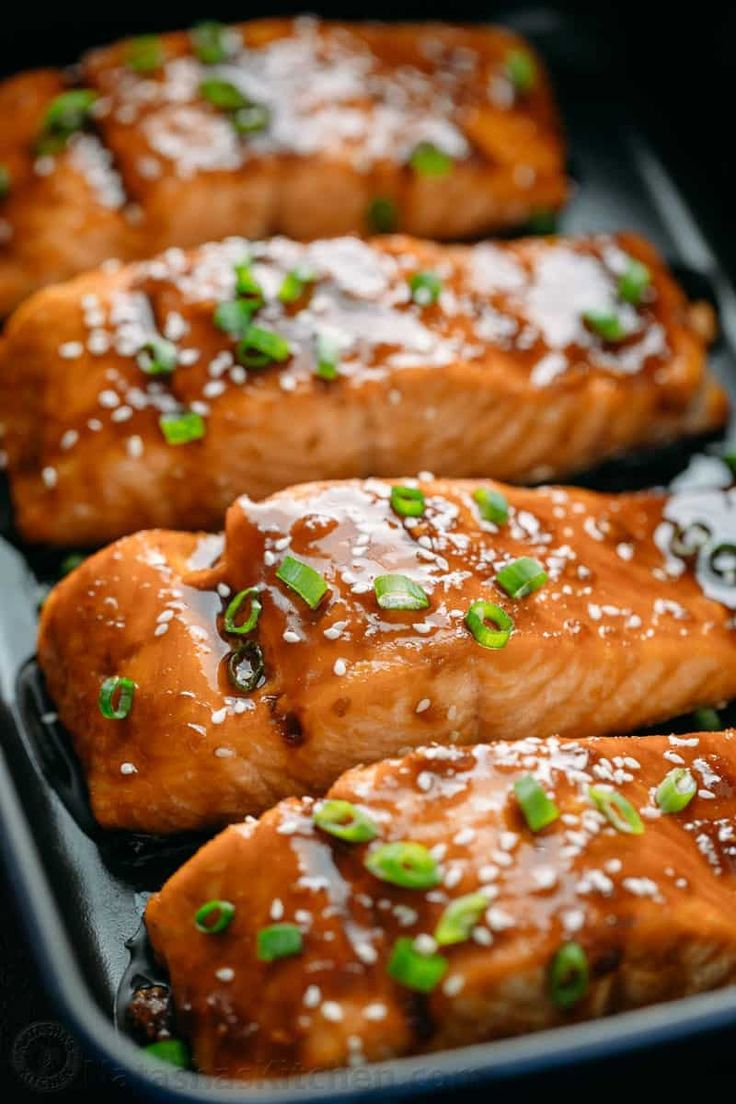 salmon with sesame seeds and green onions in a pan