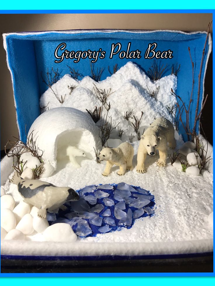 there are two polar bears in an ice box with snow on the ground and grass