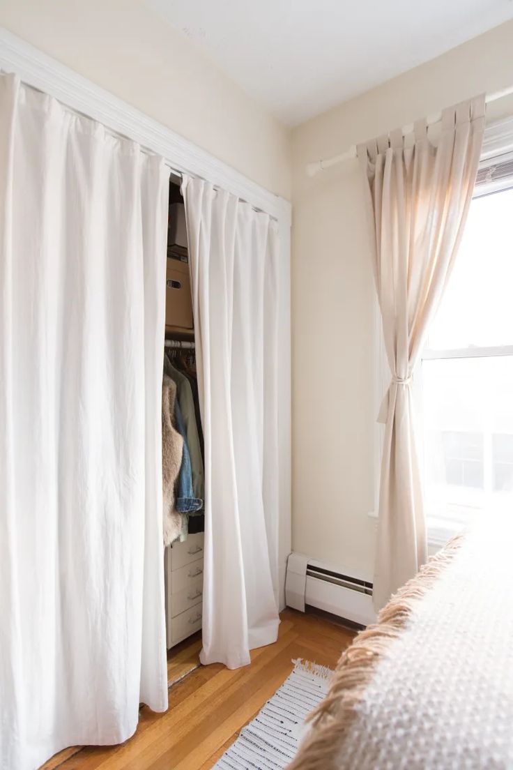 a bedroom with white curtains and a bed