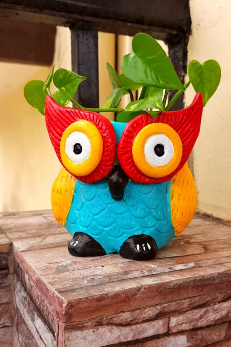 an owl planter sitting on top of a wooden table