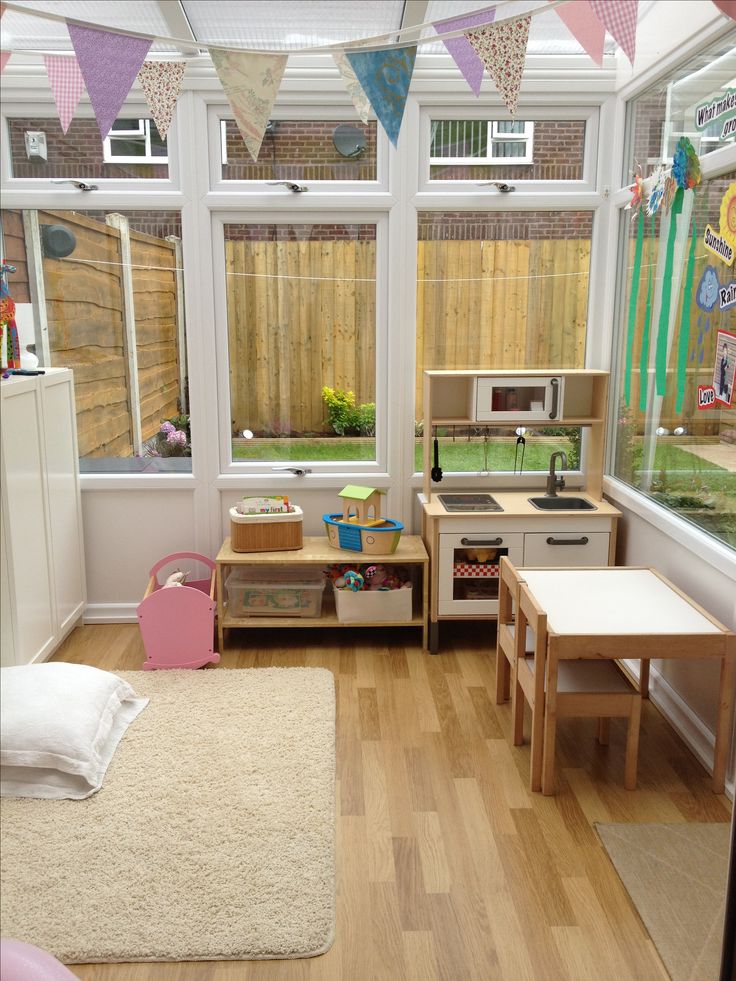 a child's play room with wooden floors and windows